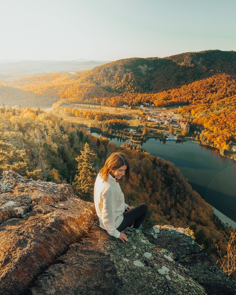 girl looking at a new england fall sunset from the top of table rock at dixville notch