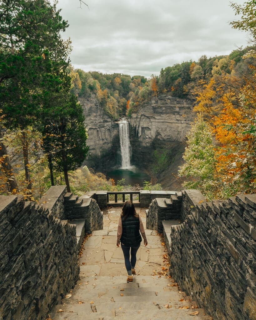 girl walking in Taughannock Falls State Park new york in the fall